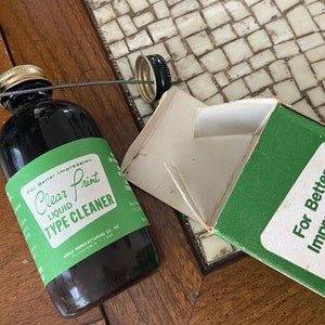 May include: A green box with the text "For Better Impressions Clear-Print Liquid No. 75" and a brown glass bottle with a green label that reads "Clear Print Liquid Type Cleaner" and a black applicator.