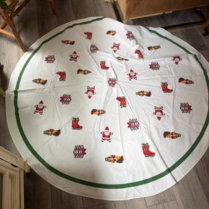 Festliche runde Tischdecke im Vintage-Stil der 70er Jahre – mit Weihnachtsmannfiguren, Geschenkboxen, Nussknackern und Stiefeln.
