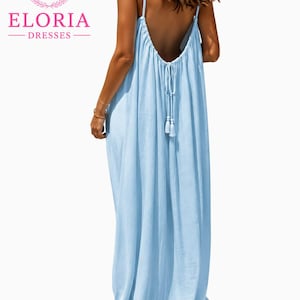May include: A light blue maxi dress featuring a low-cut open back design with thin spaghetti straps and a drawstring tie closure at the centre back, finished with two small tassels hanging from the ends of the drawstring cords.