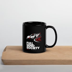 Peut inclure: Un mug en céramique noir orné d'un graphique représentant une voiture de course blanche et rouge portant le numéro 88 sur une piste. Sous la voiture, le texte FULL SEND SOCIETY est écrit en lettres capitales blanches, suivi de APEX SERIES 008.