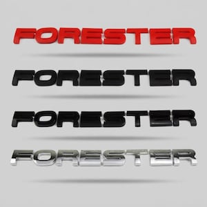 Op de afbeelding: Vier sets individuele, driedimensionale hoofdletters die het woord FORESTER spellen. De bovenste set is matrood, de tweede matzwart, de derde glanzend zwart en de onderste set heeft een reflecterende, gepolijste chroomafwerking.