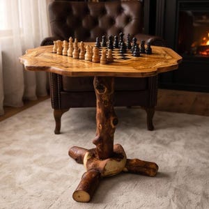 May include: A wooden chess table featuring a natural live-edge top with a visible wood grain pattern. The table is supported by a central pedestal base crafted from a thick, dark brown tree trunk section with three sturdy, branch-like feet.