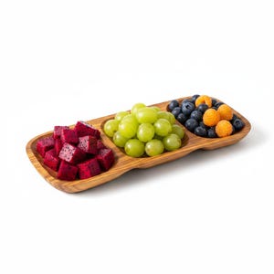 Könnte beinhalten: Ein dreigeteiltes Serviertablett aus Holz mit natürlicher Maserung, gefüllt mit gewürfelten magentafarbenen Drachenfrüchten, grünen Weintrauben sowie einer Mischung aus dunkelblauen Blaubeeren und goldgelben Himbeeren in getrennten Fächern.