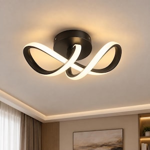 Puede incluir: Una lámpara de techo con una base circular negra y dos brazos curvos entrelazados que forman un símbolo de infinito. Los brazos tienen un exterior negro y una tira de luz blanca brillante en los bordes interiores, emitiendo una luz cálida.
