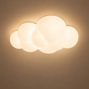 May include: A cloud-shaped ceiling light fixture composed of multiple interconnected, smooth, spherical white glass globes that emit a warm, soft, diffused glow, creating a singular, organic, and rounded silhouette against a plain background.