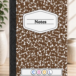 Pode incluir: Um caderno de composição castanho e branco com um padrão salpicado e lombada preta. A capa tem uma etiqueta branca com a palavra Notes impressa a preto e uma etiqueta retangular mais pequena por baixo com a palavra COOL em letras coloridas.