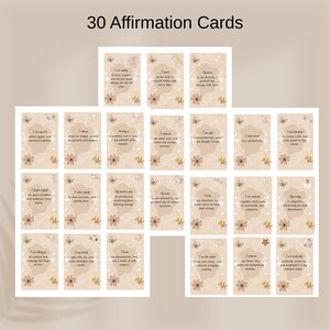 May include: A set of 30 rectangular affirmation cards featuring the text 30 Affirmation Cards at the top. Each card has a beige background with floral and butterfly illustrations, a central organic shape, and printed motivational text.