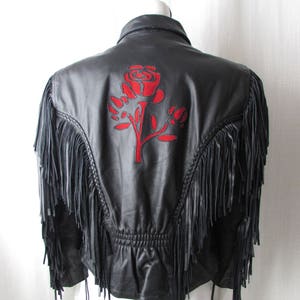 May include: Black leather jacket with fringe detailing and a red embroidered rose on the back.
