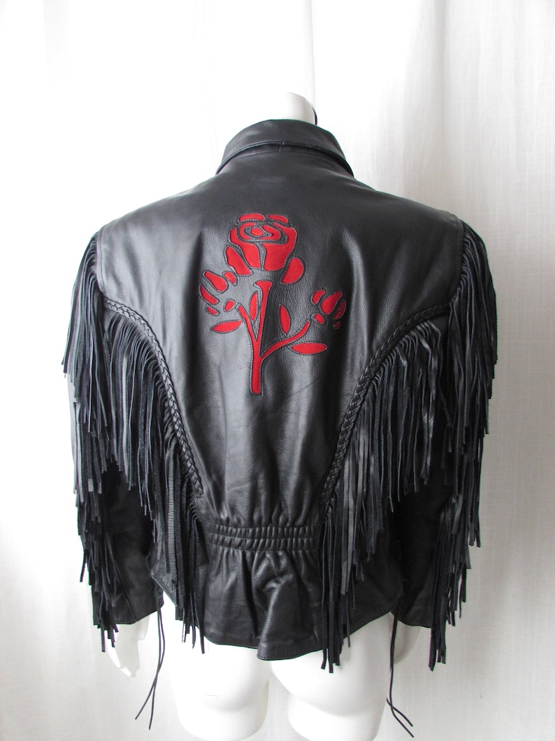 May include: Black leather jacket with fringe detailing and a red embroidered rose on the back.