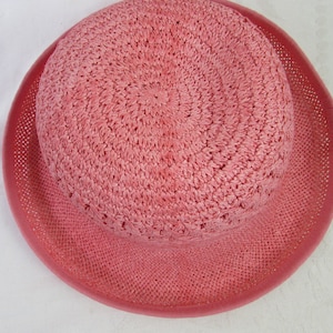 May include: A pink crocheted sun hat with a wide brim.