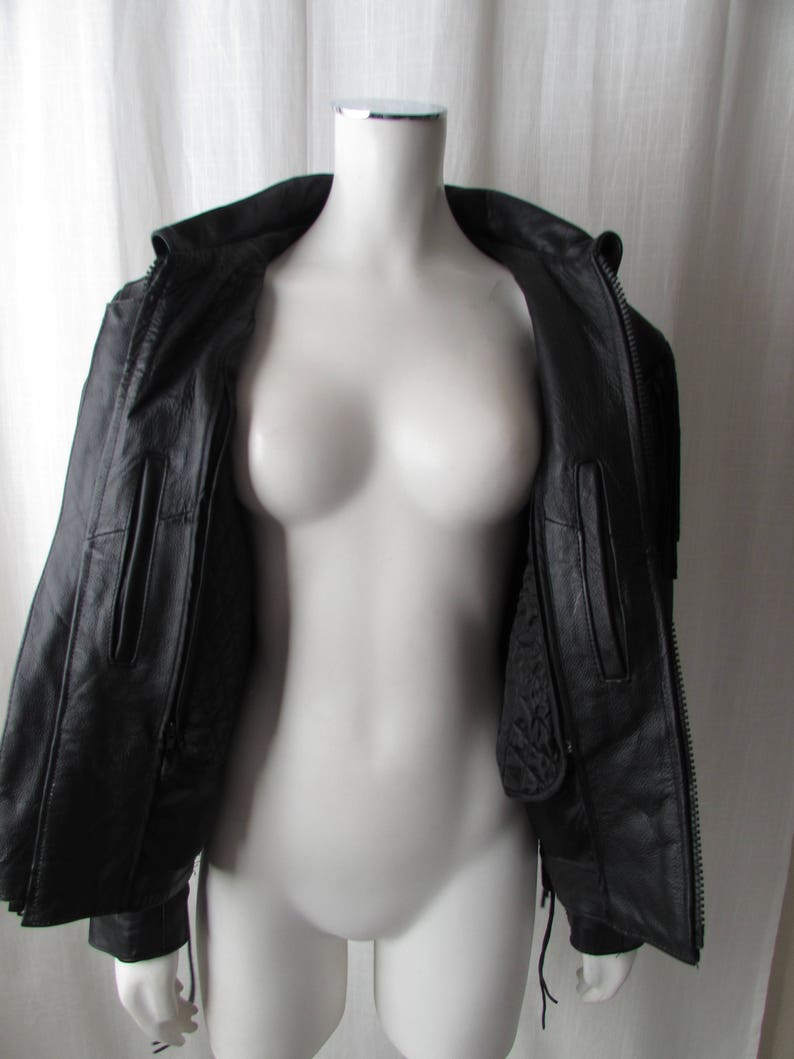 May include: Black leather jacket with a zipper closure and a quilted lining. The jacket has two pockets on the front and a drawstring at the waist.
