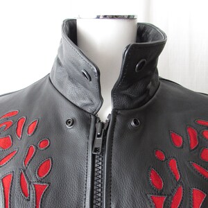 May include: Black leather jacket with a zipper closure and red embroidered roses on the front.