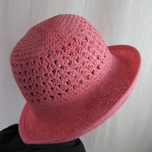 May include: A pink crocheted sun hat with a wide brim.