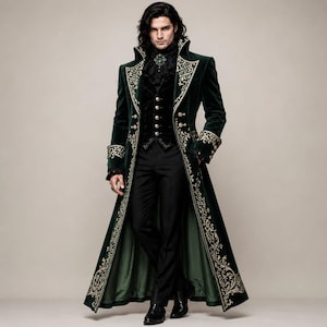 Puede incluir: Un abrigo largo de terciopelo verde oscuro con intrincados bordados dorados en las solapas, puños y dobladillo. Se lleva sobre un chaleco negro con botones plateados, una camisa negra con volantes y un broche verde, y pantalones negros.