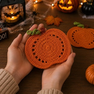 Peut inclure: Deux dessous de verre au crochet en forme de citrouille orange, dotés d'un centre circulaire, d'une bordure décorative à points ouverts et d'une petite tige verte. Ces dessous de verre sont réalisés en fil et présentent un aspect texturé.