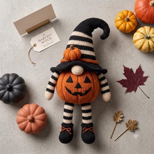 May include: A knitted gnome figure with a pumpkin-shaped body featuring a jack-o'-lantern face, wearing a black and white striped hat with a small pumpkin accent. The gnome has striped arms and legs, black shoes with orange laces, and a tag reading HARVEST WITCH.