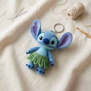 Può includere: Un portachiavi all'uncinetto raffigurante un personaggio blu con grandi orecchie, interno delle orecchie viola chiaro e occhi neri. Il personaggio indossa una gonna verde e ha un naso blu scuro. Un anello metallico è fissato sulla testa.