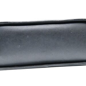 Puede incluir: Bolso de mano de cuero negro con un fondo liso y plano.