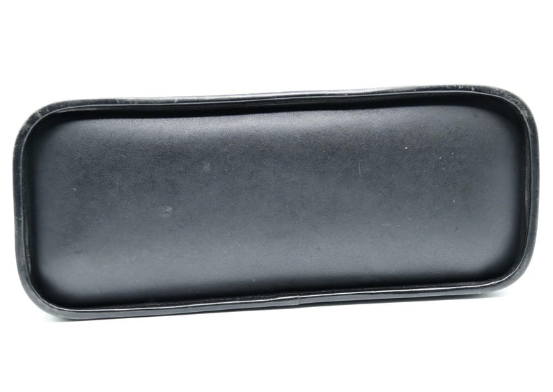 Puede incluir: Bolso de mano de cuero negro con un fondo liso y plano.