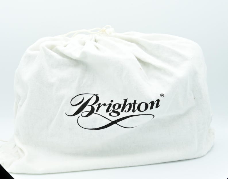 Puede incluir: Bolsa de polvo de algod&oacute;n blanco con letras negras que dicen "Brighton" con un s&iacute;mbolo de marca registrada.