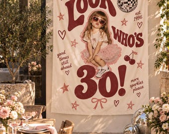 May include: A cream-colored fabric banner featuring the dark red text Look Who's 30!, a central photograph of a child in a pink tutu and heart-shaped sunglasses, and decorative illustrations of a disco ball, cherries, stars, and bows.