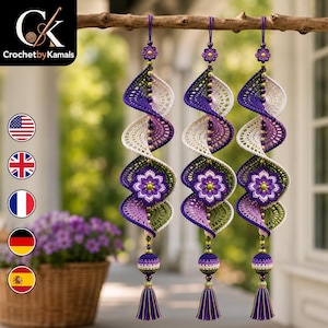 Peut inclure: Trois ornements suspendus en spirale identiques, réalisés en fil crocheté dans des tons violet, crème et vert olive. Chaque pièce présente une fleur crochetée centrale, des perles décoratives et un pompon avec des fils violets et dorés.