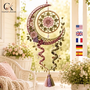 Pode incluir: Uma tapeçaria de crochê em forma de meia-lua com uma mandala circular central com uma flor rosa, adornada com folhas verdes, flores menores rosas e roxas, duas vinhas de crochê em espiral e uma borla multicolorida na parte inferior.