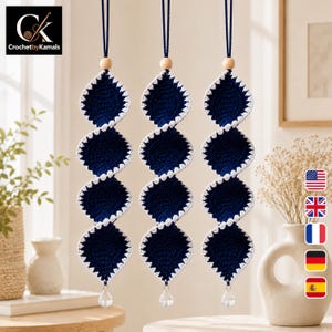 May include: Three hanging spiral ornaments crafted from dark navy blue yarn with white crocheted edges. Each piece features a natural wooden bead at the top and a clear, faceted crystal-like drop at the bottom, suspended by a thin navy blue cord.