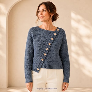 May include: A blue long-sleeved sweater with a textured crochet pattern and a diagonal button placket featuring light brown wooden buttons. The sweater has a ribbed hem and cuffs, with a round neckline and a structured, asymmetrical design.