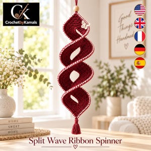 Può includere: Un decoro a spirale in uncinetto color rosso scuro con bordo bianco cucito, una piccola decorazione a farfalla bianca, una perla di legno in alto e una nappa rossa abbinata sul fondo. Il testo CrochetbyKamals è visibile.