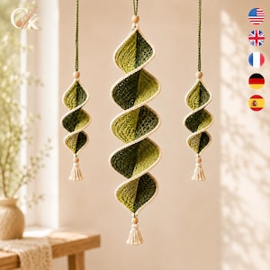 Può includere: Tre ornamenti a spirale sospesi realizzati in filo di cotone verde all'uncinetto con bordi color crema. Ogni pezzo presenta una perla di legno in alto e una piccola nappa color crema in basso, appesi a cordoncini intrecciati verdi.