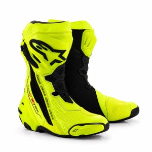 Può includere: Un paio di stivali da moto a taglio alto in giallo neon e nero. Gli stivali presentano il logo Alpinestars sul lato, il marchio Supertech, sezioni traforate sulla punta e sullo stinco e una struttura del tallone rinforzata con accenti neri.