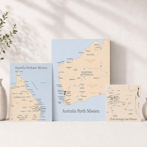 May include: Three rectangular wall art prints featuring maps. The left print shows the Australia Brisbane Mission, the center print displays the Australia Perth Mission, and the right print depicts the Chile Santiago East Mission with black text.