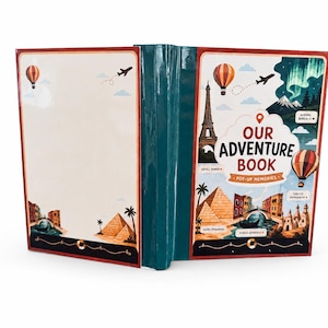 May include: A teal-colored scrapbook titled Our Adventure Book Pop-Up Memories. The cover features illustrations of the Eiffel Tower, pyramids, a gondola, hot air balloons, and the aurora borealis. The back cover is blank with small travel icons.