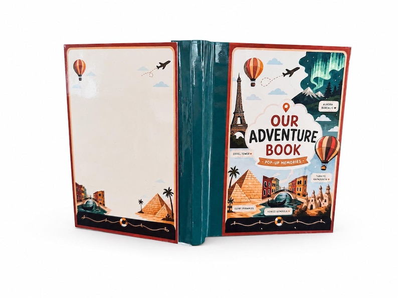 May include: A teal-colored scrapbook titled Our Adventure Book Pop-Up Memories. The cover features illustrations of the Eiffel Tower, pyramids, a gondola, hot air balloons, and the aurora borealis. The back cover is blank with small travel icons.