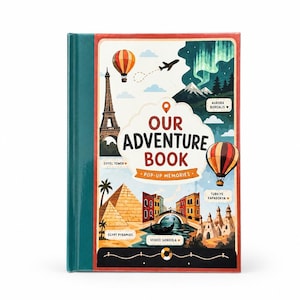 Our Adventure Book, a personalized 3D pop-up travel book with 5 destinations. The closed book cover stands beside an open page featuring a hand-illustrated Eiffel Tower, with two custom illustrated figures created from the customer's own photos standing on a cobblestone path.