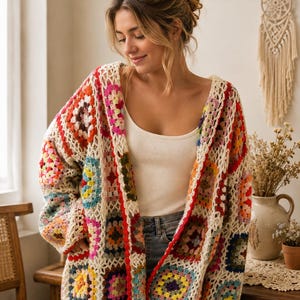 May include: A long-sleeved cardigan constructed from multi-coloured crochet granny squares in shades of red, yellow, blue, green, and pink, joined by an off-white yarn border. The garment features an open front design with a scalloped red edge.