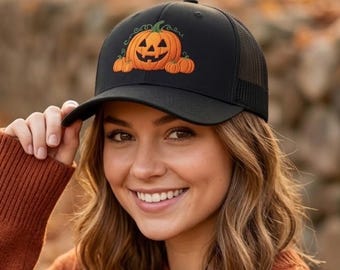 May include: A black baseball cap featuring an embroidered graphic of a central orange jack-o'-lantern with a carved face, flanked by two smaller orange pumpkins on either side. The cap has a solid front panel and a mesh back panel construction.