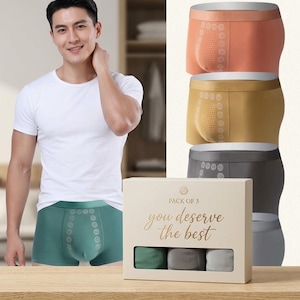May include: A pack of three boxer briefs in orange, gold, and grey, featuring a textured front panel with circular patterns. The packaging is a beige box with the text "PACK OF 3" and "you deserve the best" printed in gold lettering on the front.