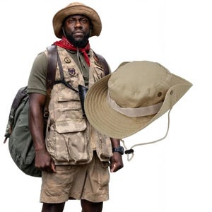 May include: A tan wide-brimmed bucket hat with a matching adjustable chin strap and a side snap button. The hat features a structured crown and a wide brim, designed with a neutral beige fabric finish and a simple, functional aesthetic.
