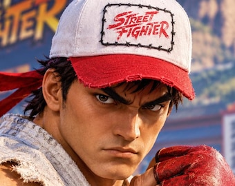 May include: A white baseball cap with a red brim and a rectangular patch featuring the red text Street Fighter surrounded by a black barbed wire graphic. The cap has a small red button on top and a distressed, frayed edge along the brim.