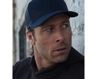 May include: A solid navy blue baseball cap featuring a structured crown and a curved brim. The side panels of the cap are constructed from a breathable mesh material, while the front panels are made of a smooth, opaque fabric in a matching shade.