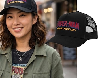 May include: A black trucker cap featuring a mesh back panel and a structured front panel. The front displays embroidered text in red and blue that reads Spider-Man, with the words Brand New Day stitched in yellow underneath the main title.