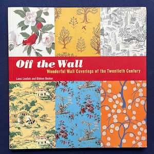 May include: A hardcover book titled Off the Wall: Wonderful Wall Coverings of the Twentieth Century by Lena Lenček and Gideon Bosker. The cover features a grid of six distinct vintage wallpaper patterns in floral, landscape, and geometric designs.