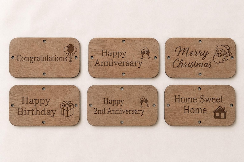 May include: Six rectangular brown wooden tags with rounded corners and four small holes each. The tags feature laser-engraved text and icons: Congratulations with balloons, Happy Anniversary with glasses, Merry Christmas with Santa, Happy Birthday with a gift, Happy 2nd Anniversary with glasses, and Home Sweet Home with a house.