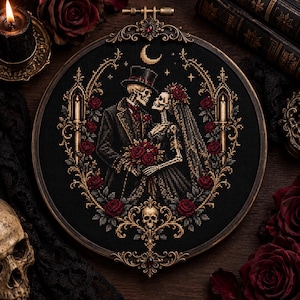 May include: A circular embroidery hoop containing a cross-stitch design of two skeletons dressed as a bride and groom. The figures are surrounded by a gold ornate frame with red roses, candles, and a crescent moon on a black fabric background.