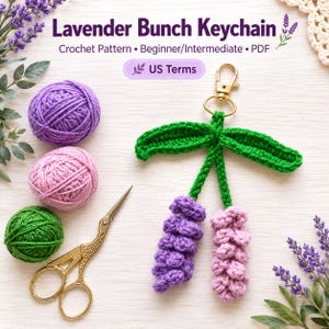 May include: A crochet pattern PDF for a Lavender Bunch Keychain with US terms. The image displays a finished lavender keychain with two purple and pink crocheted flowers, green leaves, and a gold clasp, alongside yarn balls and gold scissors.