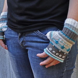 May include: A pair of blue and brown striped fingerless gloves with white accents and silver beads. The gloves are knitted and have a star pattern.