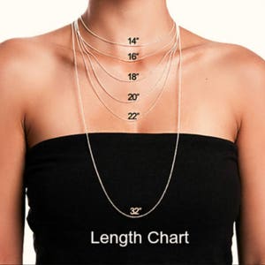May include: A woman wearing a black tube top displays a necklace length chart. The chart shows silver chain necklaces in lengths of 14", 16", 18", 20", 22", and 32". The text "Length Chart" is at the bottom.