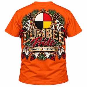 May include: An orange short-sleeve t-shirt featuring a graphic on the back with the text "LUMBEE PRIDE" and "POWER STRENGTH". The design includes a circular four-colored emblem, pine cones, and feathers in red, white, and black.